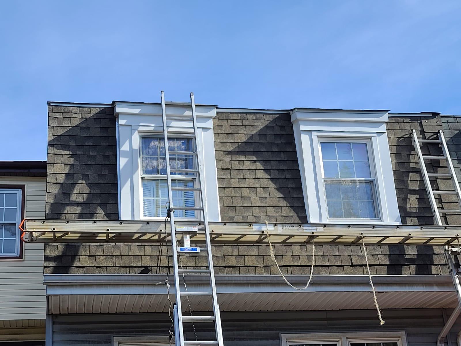 Scaffolding is set up to inspect a mansard roof and dormers